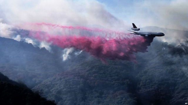 Літак скидає речовину, що пригнічує вогонь, біля Малібу в Каліфорнії, 11 листопада 2018